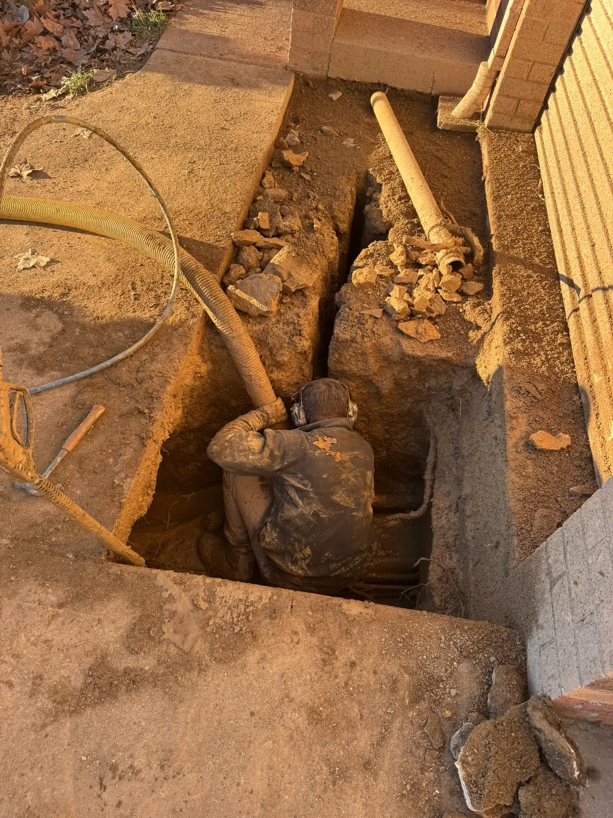 Exposed underground pipework in a small excavation