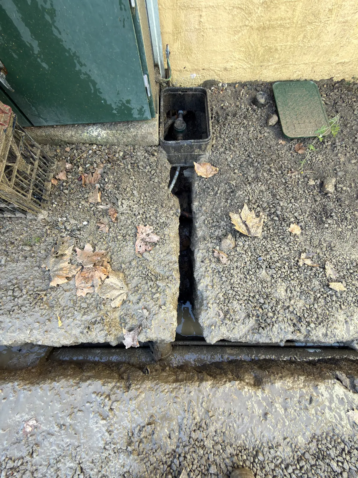 A narrow trench beside a house and garden area