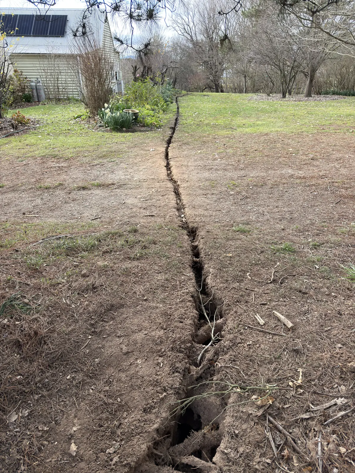 A long narrow trench extending across a lawn