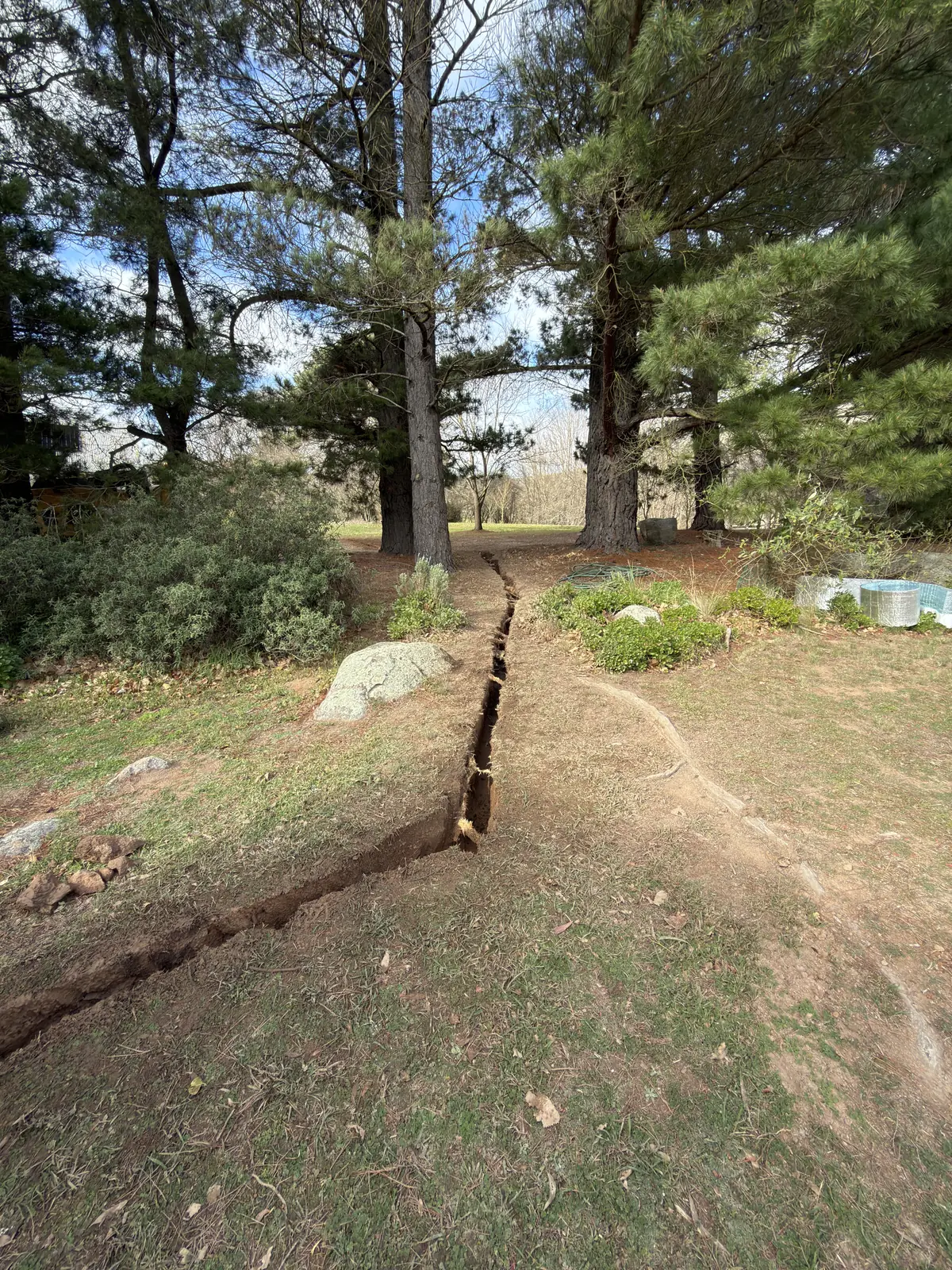 A shallow trench through a landscaped garden area
