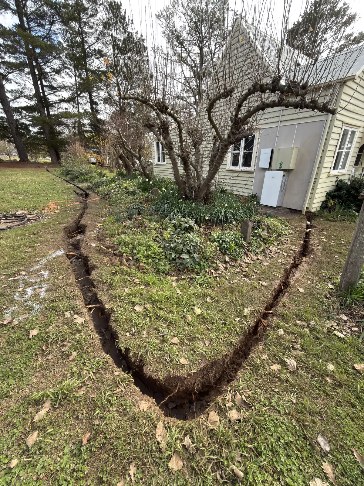 A curved trench running around a house garden