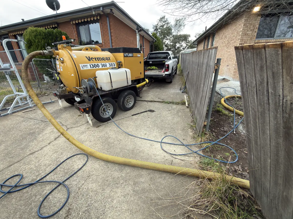 GreenVac vacuum trailer set up in a narrow residential driveway